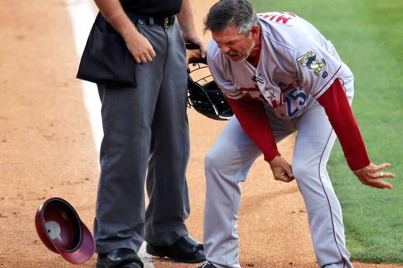 Frisco RoughRiders manager Joe Mikulik throws his helmet to the ground in frustration while...