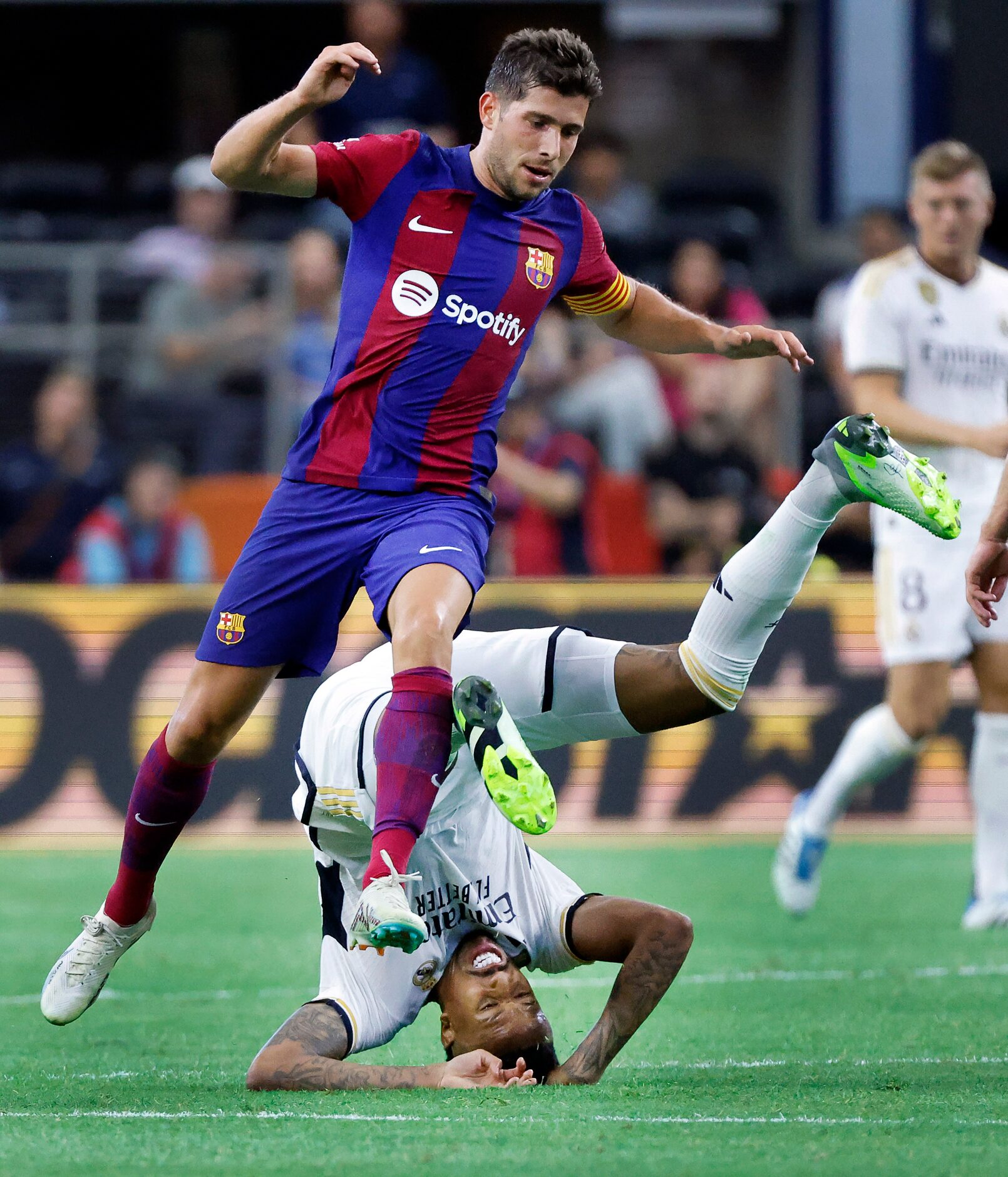 Real Madrid defender Éder Militão (3) is rolled up by Barcelona defender Sergi Roberto (20)...