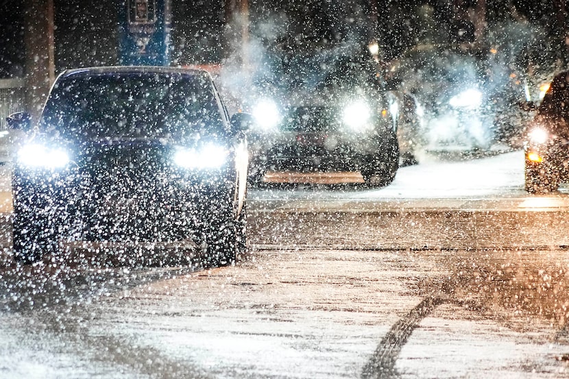 Snow falls over cars lined up for passenger pickup at  DFW International Airport in the...