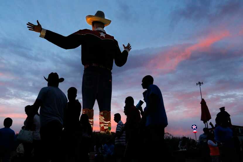 As the sun sets on the last day of the State Fair of Texas, fairgoers pass thru Big Tex...