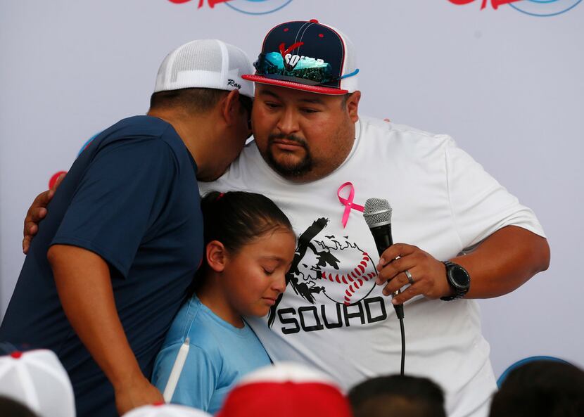 Ray Garcia (left) of El Paso hugged Danny Latin) and his daughter at the end of the...