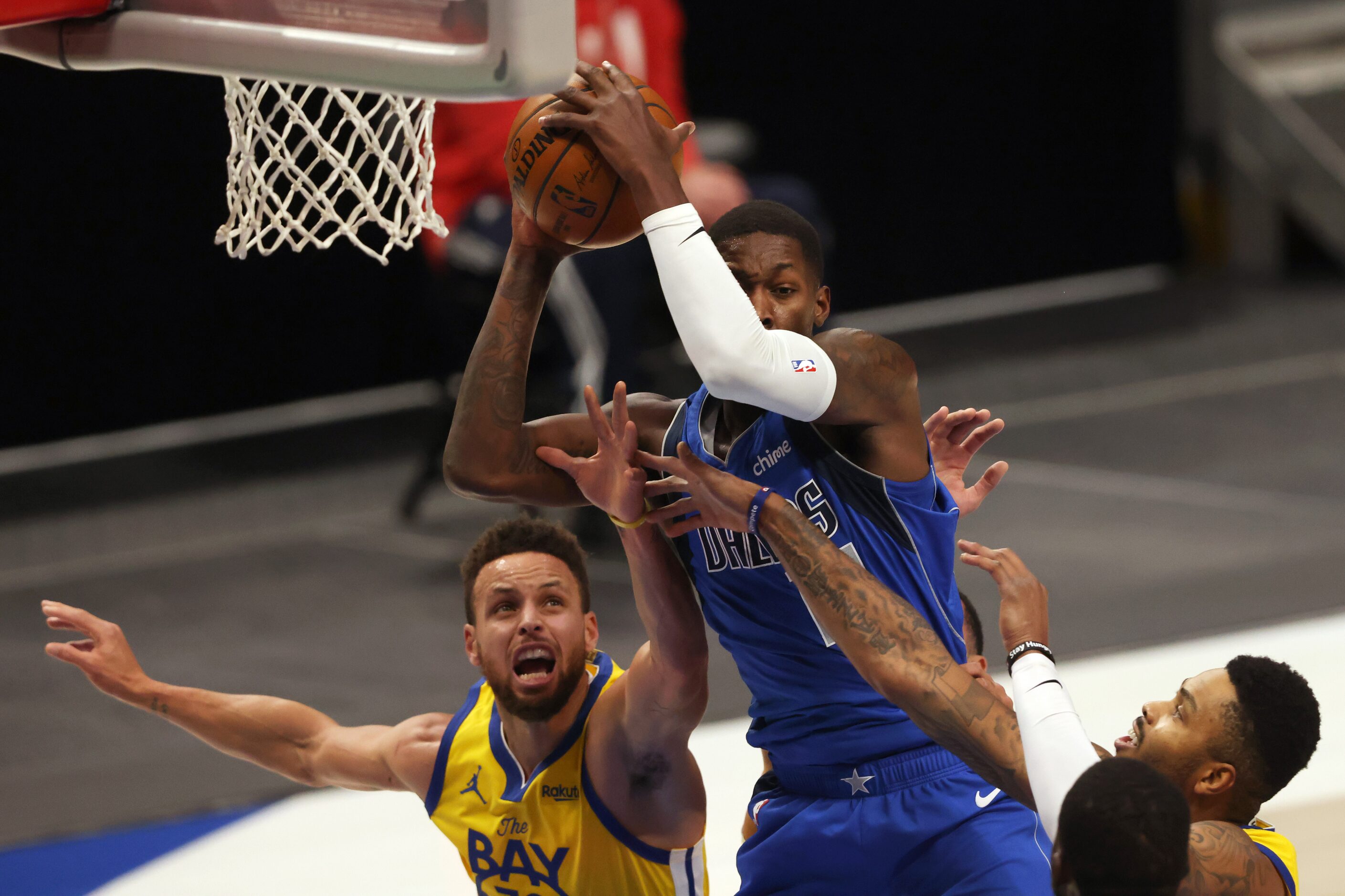 Dallas Mavericks forward Dorian Finney-Smith (10) grabs a rebound in front of Golden State...