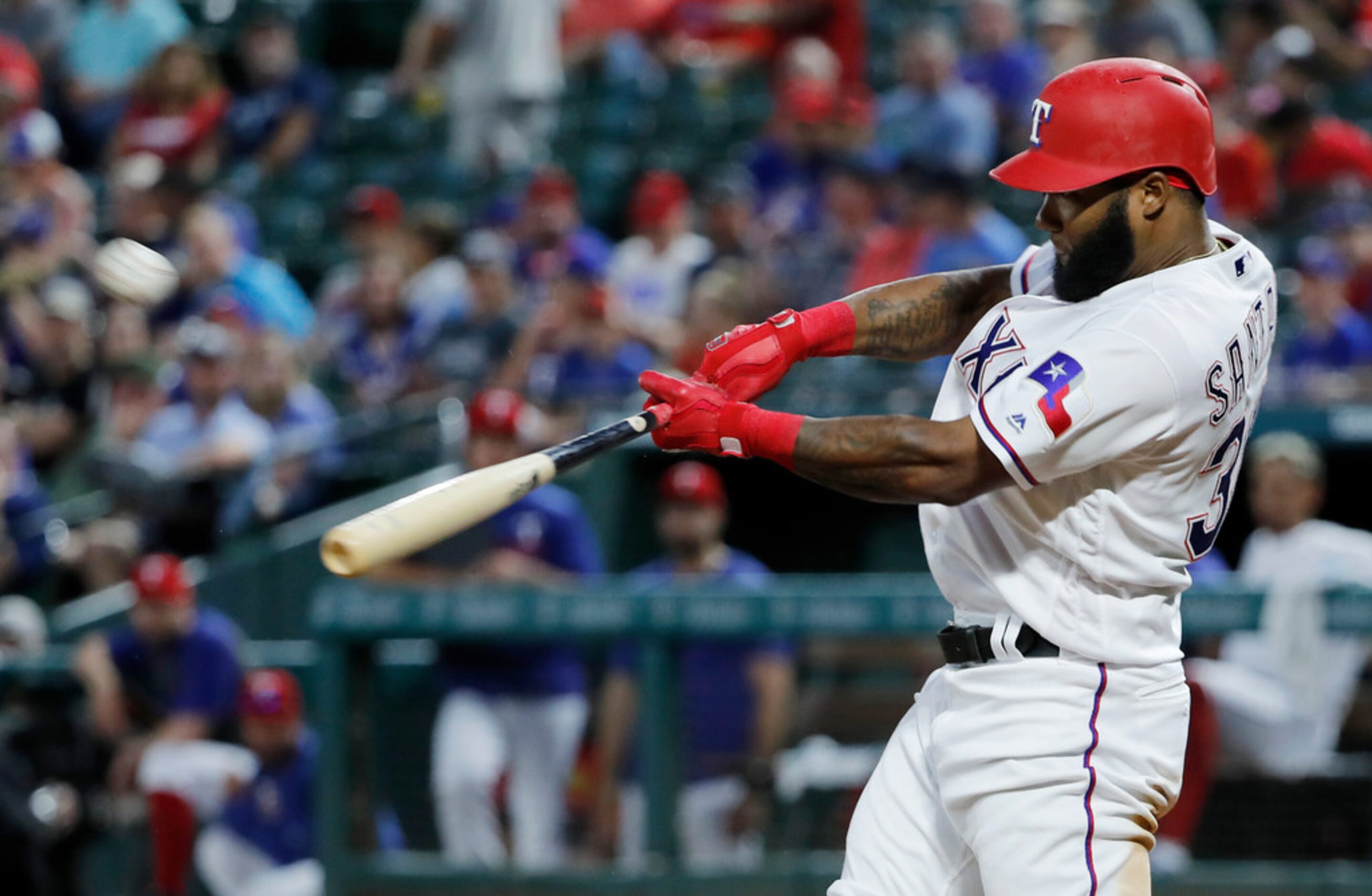 Texas Rangers' Danny Santana hits an RBI sacrifice fly during the fifth inning of a baseball...