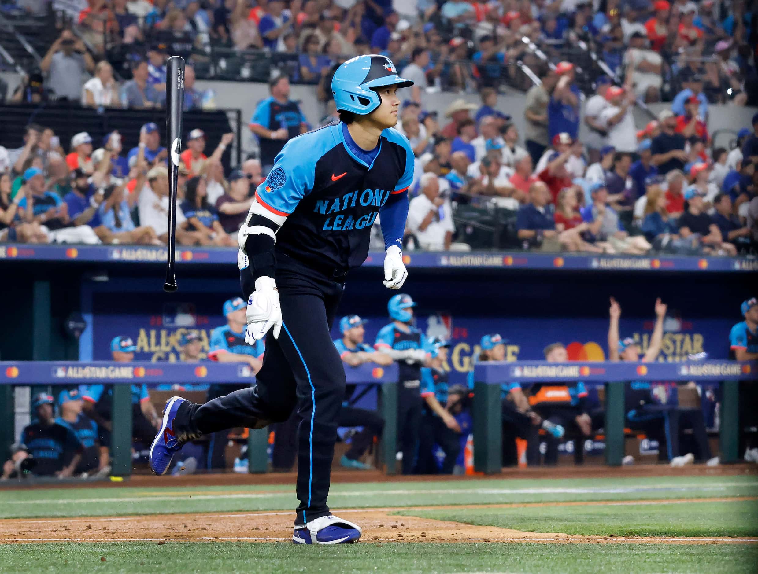 National League's Shohei Ohtani, of the Los Angeles Dodgers, flips his bat after hitting a...