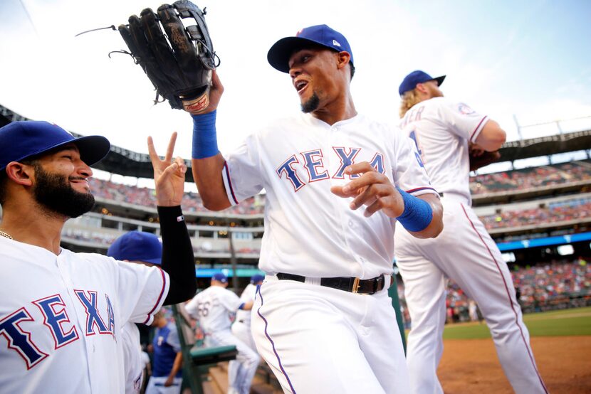 Texas Rangers center fielder Carlos Gomez (right) and right fielder Nomar Mazara (30) joke...