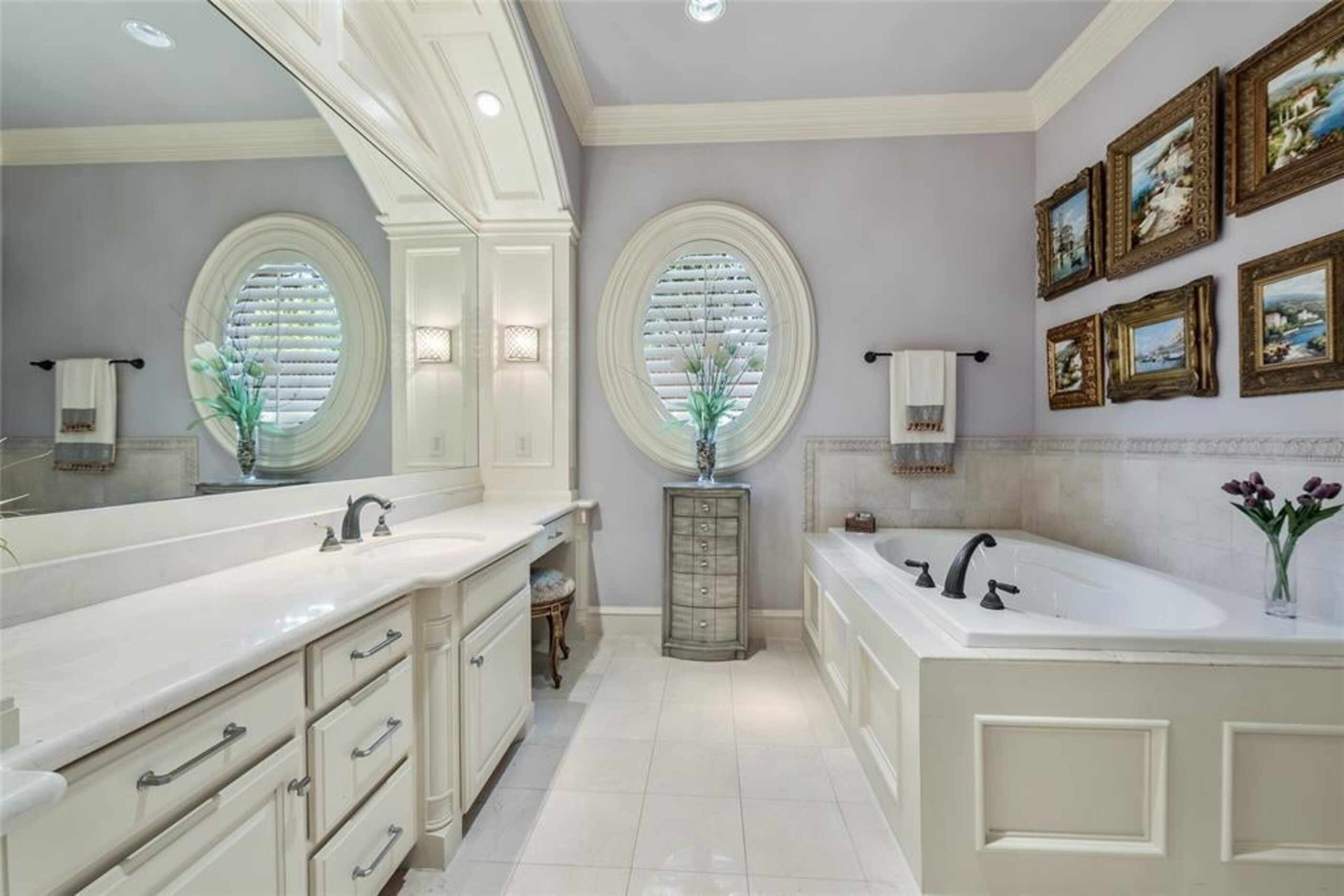 The main-floor master suite has an oval window that adds elegance to the bathroom.