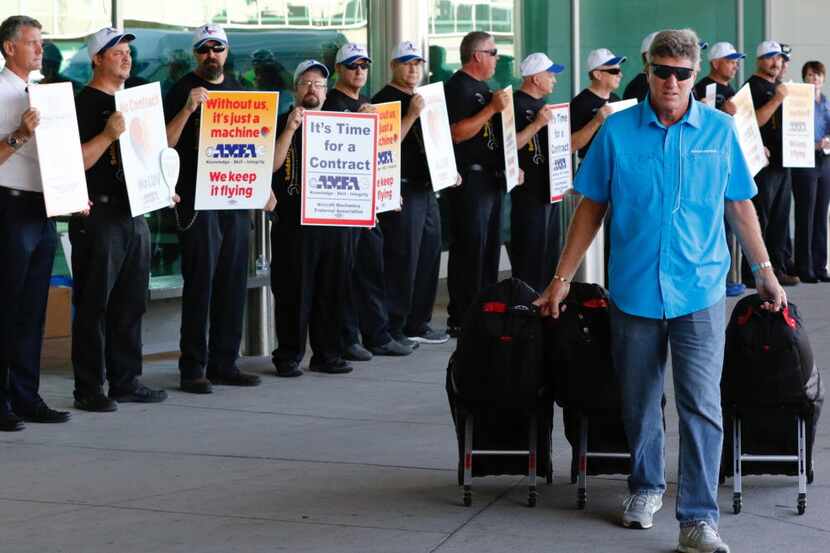 Robert Merino of Plano walked past Southwest Airlines flight attendants picketing for...
