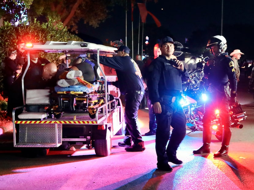 Dallas Fire-Rescue EMS loads one of the wounded onto a cart after a shooting at the State...