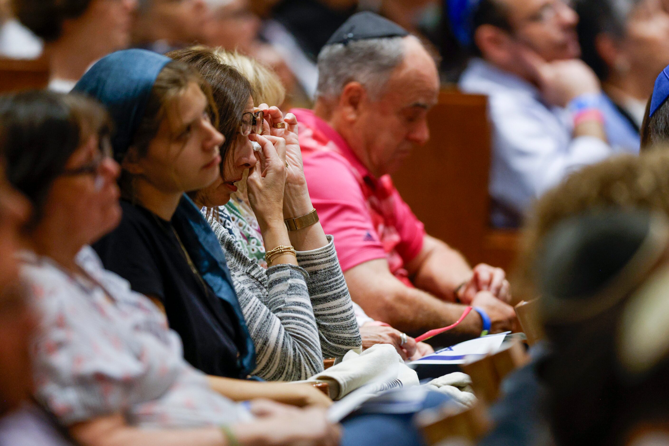 A woman wipes away tears as she listens to a testimony by LeElle Slifer about her cousin who...