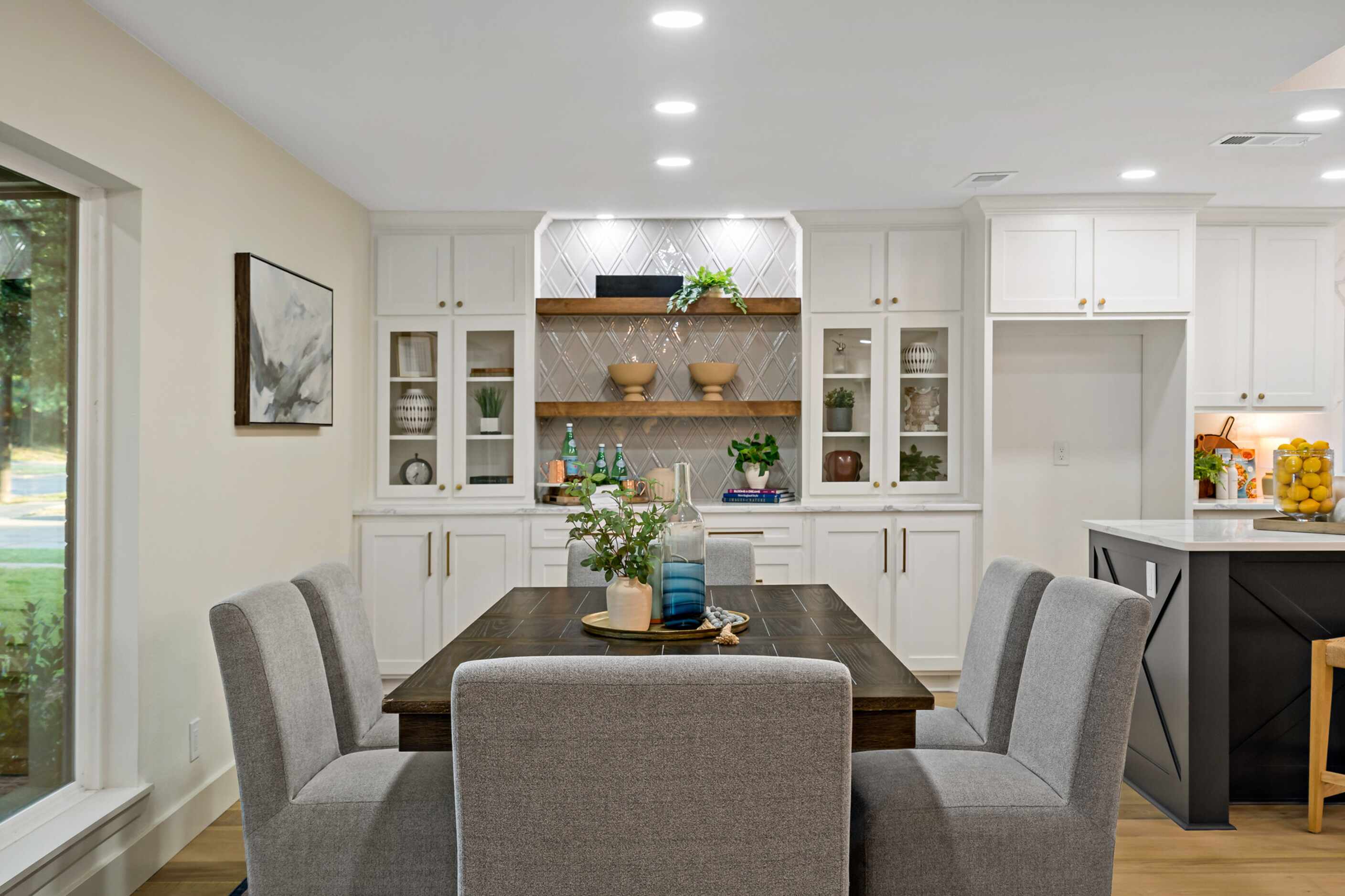 Dining table with gray chairs, white built-in cabinetry in the background