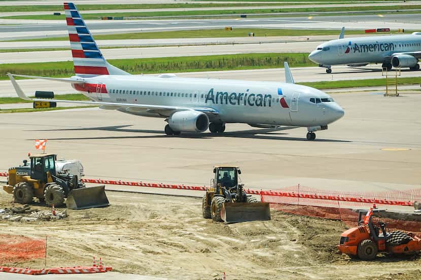 An American Airlines 737-800 taxis past construction on the ramp near Terminal C at DFW...