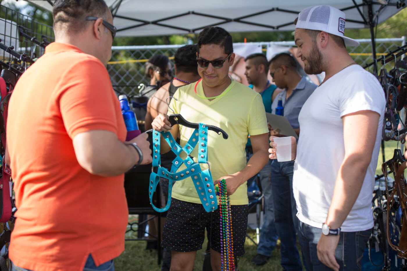 Alvin Alarcon (center) of Dallas inspects a harness during the Texas Latino Gay Pride...