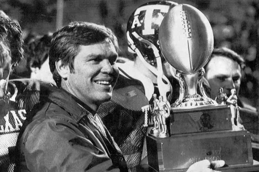 Texas A&M head football coach Tom Wilson holds up the Indepence Bowl trophy after his team...