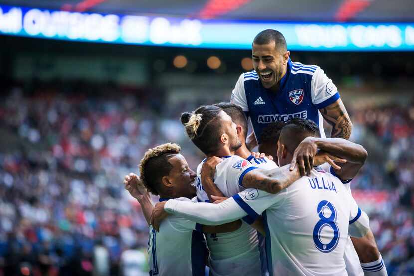 FC Dallas' Matt Hedges, back left, is mobbed by his teammates as they celebrate his goal...
