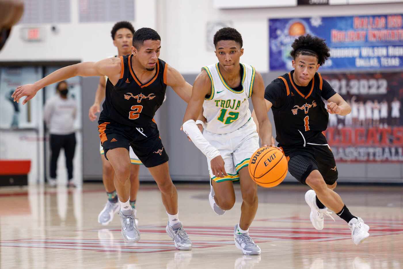 Madison guard Brandon Patterson (12) dribbles between W.T. White guards Raul Nieves (2) and...