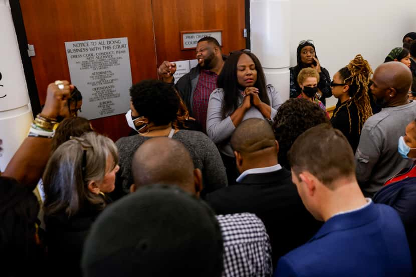 People pray outside of 369th District Court before the verdict is announced in the murder...