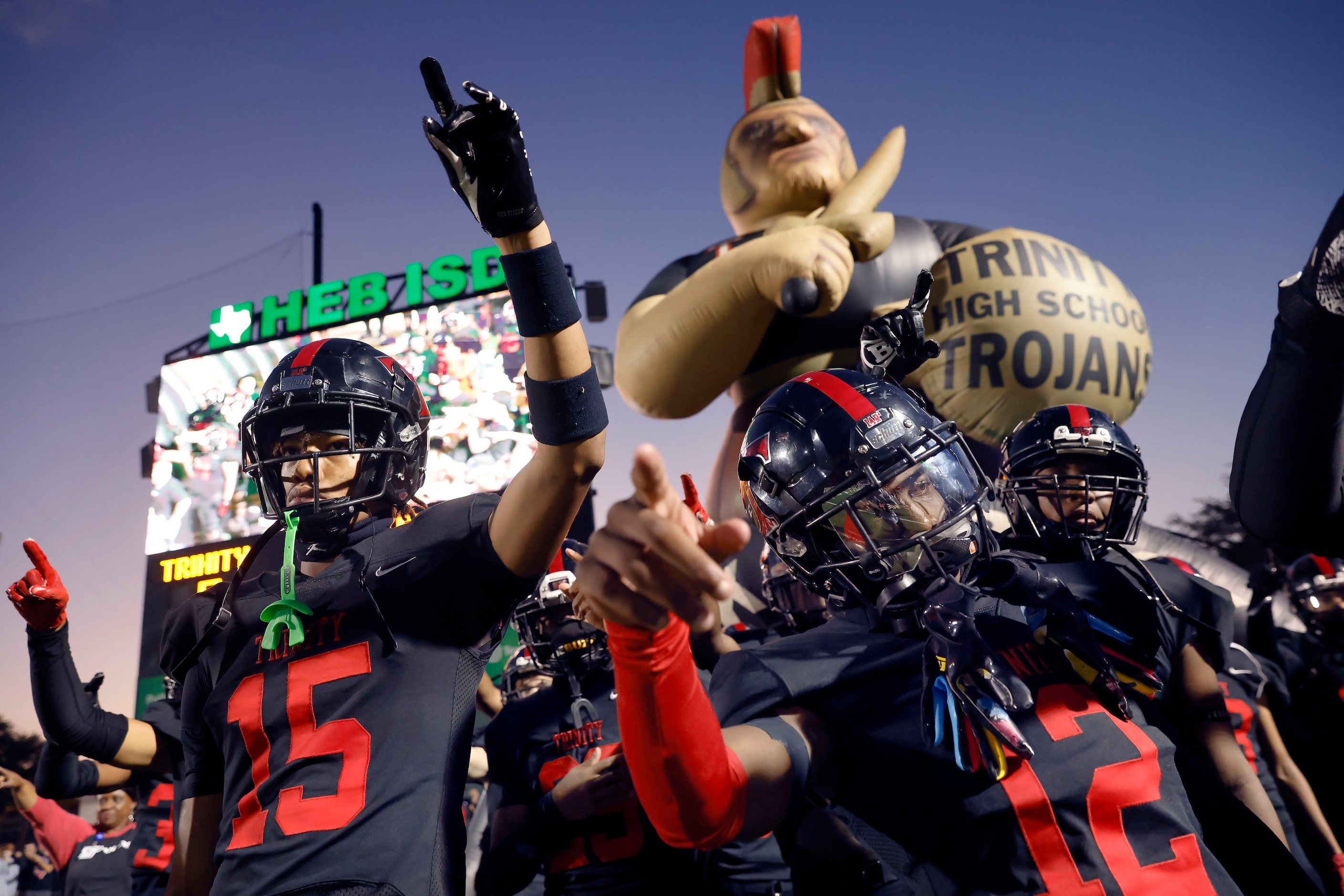 Euless Trinity football players, including Jarvis Heimuli (15) and Lamont Potts (12),...