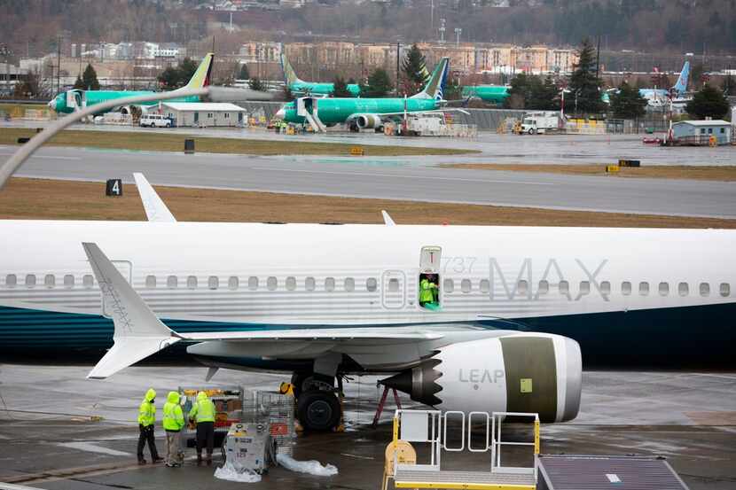 Workers are pictured next to a Boeing 737 Max 9 airplane on the tarmac at the Boeing Renton...