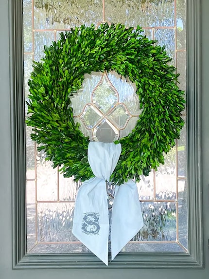 Blue sash on a green wreath on the front door