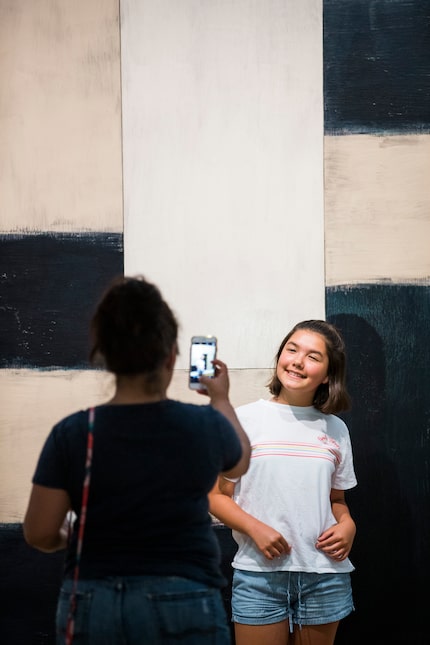 Hermalinda Idrogo, left, takes a photo of Eva Idrogo, 12, in front of "Catherine, 1993" by...