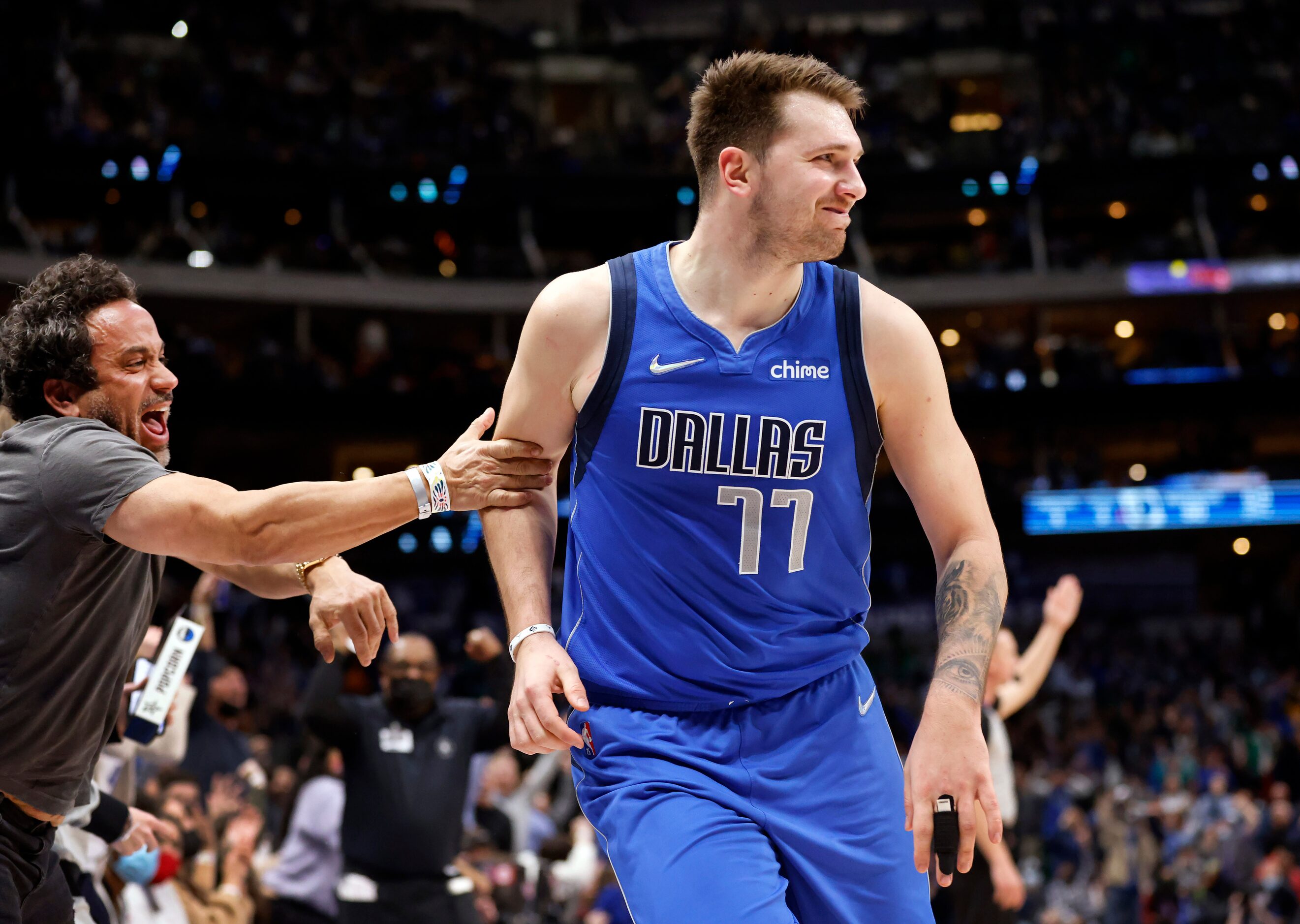 Court-side fans congratulate Dallas Mavericks guard Luka Doncic (77) after he made an...