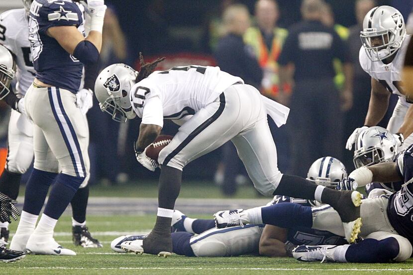 Oakland Raiders wide receiver Greg Jenkins (10) picks up a fumble on the opening kickoff and...