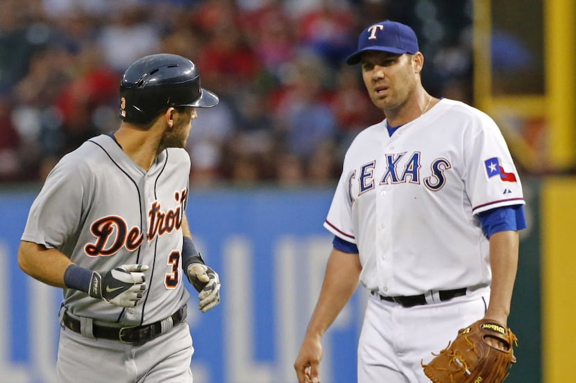 Detroit second baseman Ian Kinsler and Texas starting pitcher Colby Lewis exchange...