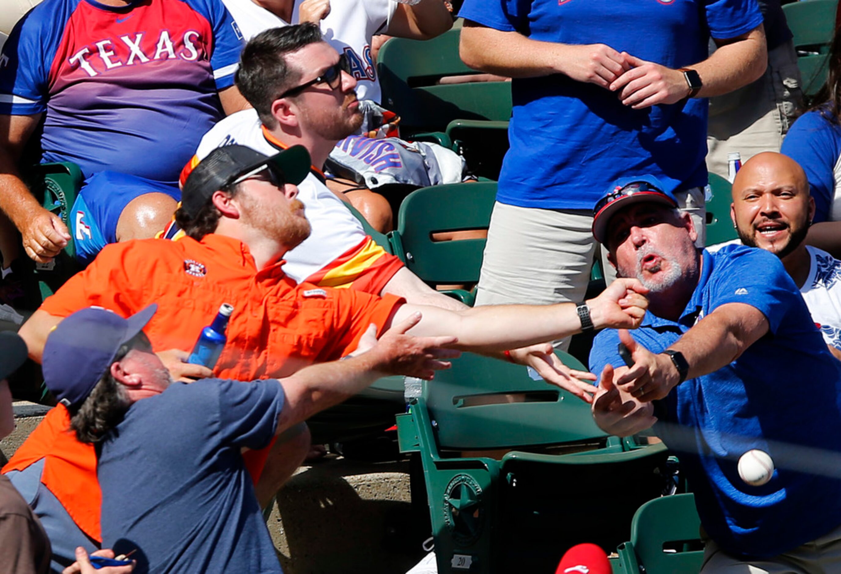 Series 1 of 4 -- Two Houston Astros fans reach for a foul ball in the aisle of the lower...