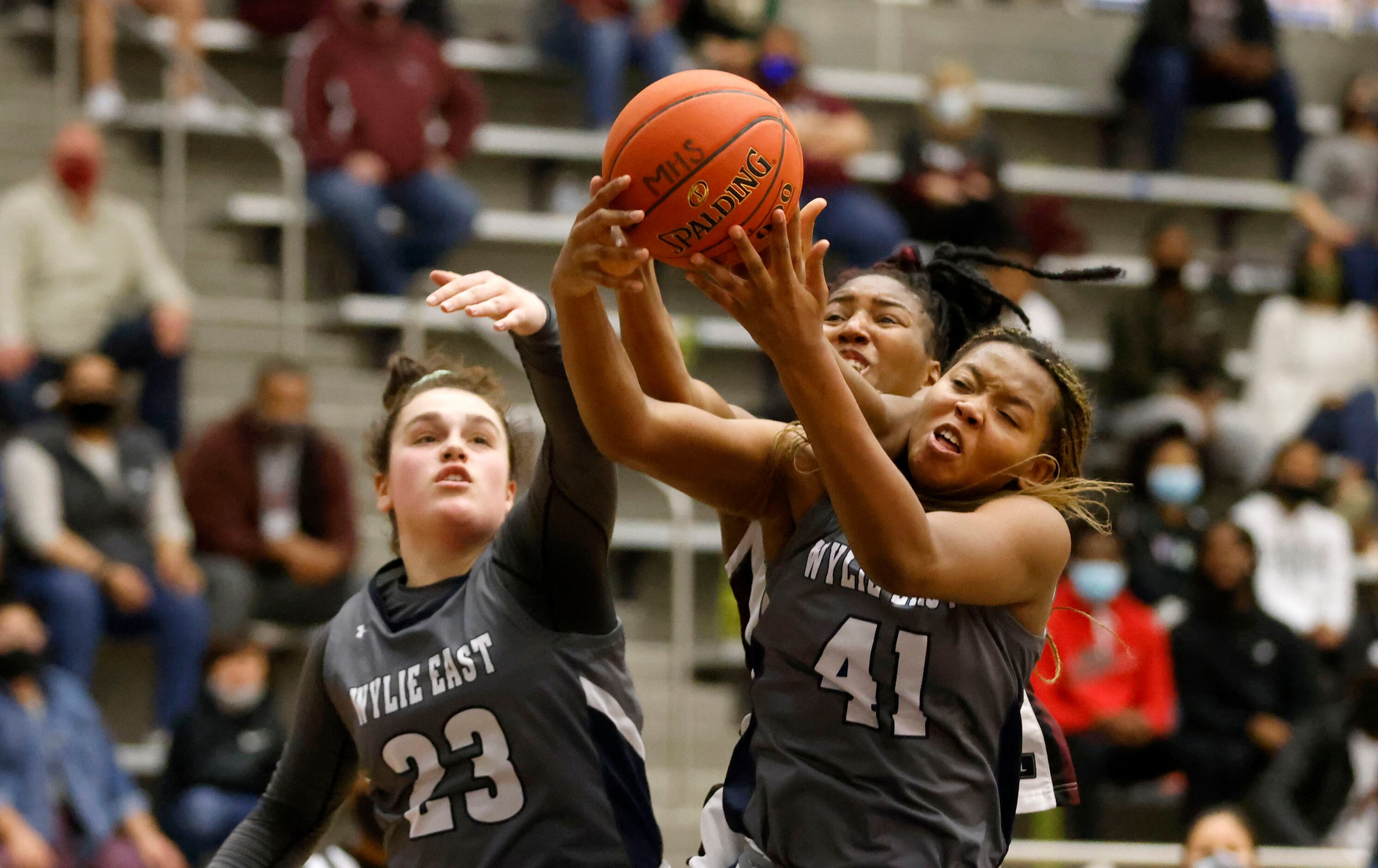Wylie East’s Kiley Hicks (23) and Akasha Davis (41) go for a rebound in front of Red Oak’s...