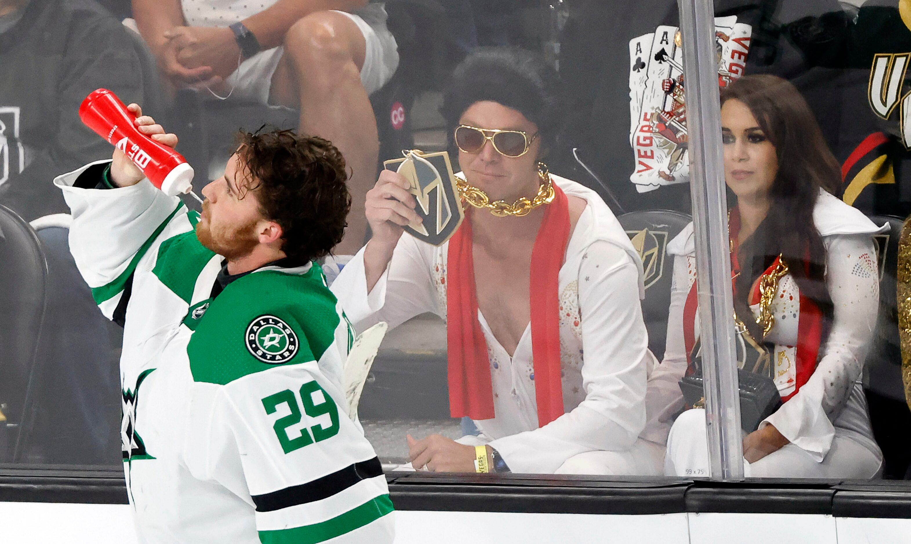 Dallas Stars goaltender Jake Oettinger (29) takes a swig of water as Elvis impersonators...