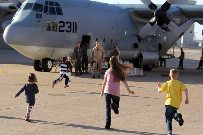 Children sprinted toward a C-130 to greet their dads at Naval Air Station Joint Reserve Base...