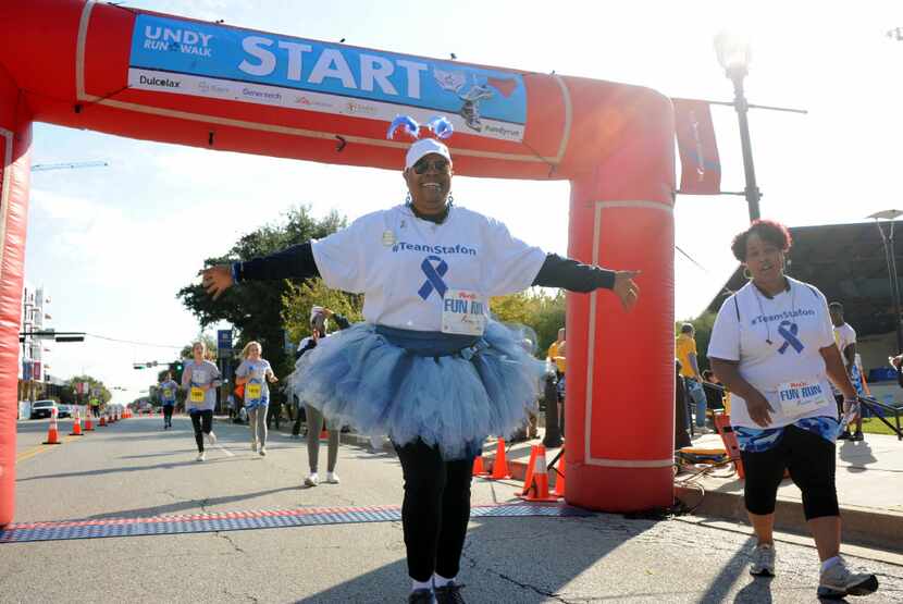 Colon cancer survivor Stafon Jackson cheers as she reaches the finish line at the Undy Run...