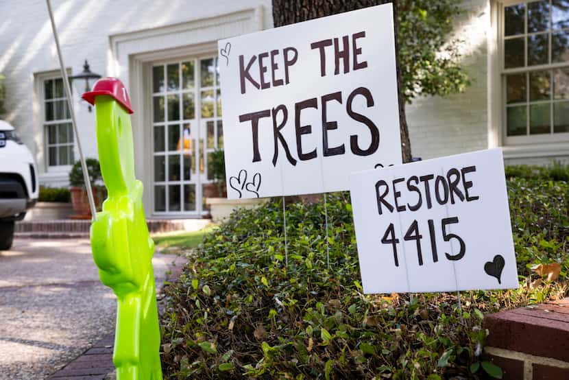 A sign saying “Keep the Trees” and “Restore 4415” seen across the street as a crew works to...