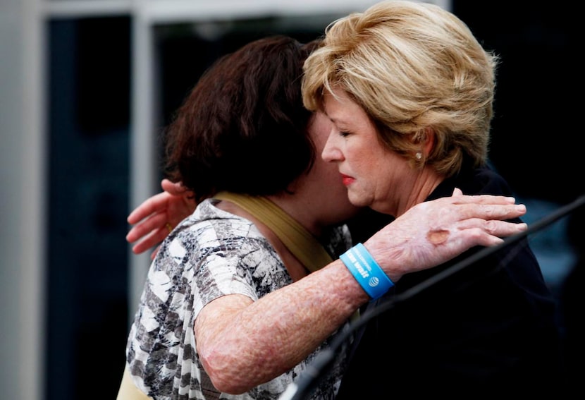 
Jamie Nash Wiens (at left) hugs Cathy Coughlin during the Drive 4 Pledges Day event as part...