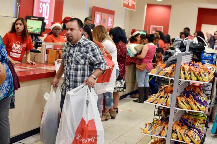 Early Black Friday shopper Jose Contreras leaves with a bag of items, on Thursday, Nov. 24,...