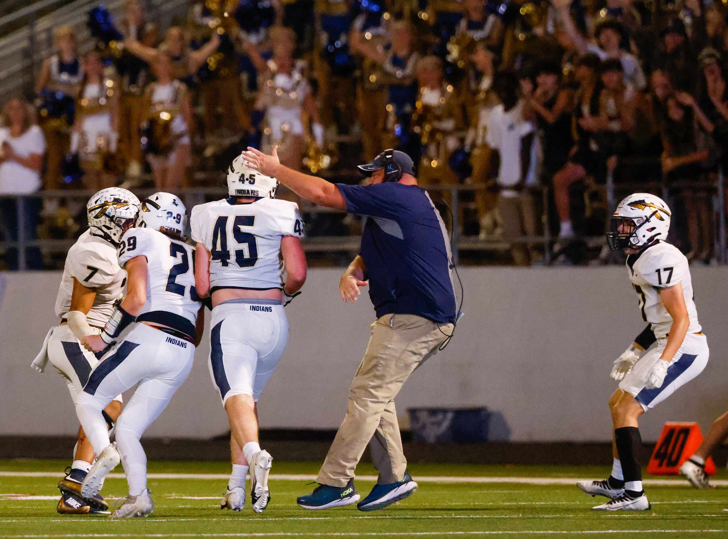 Keller High School defensive line Ethan Starr (45) receives a hit on his helmet from a coach...