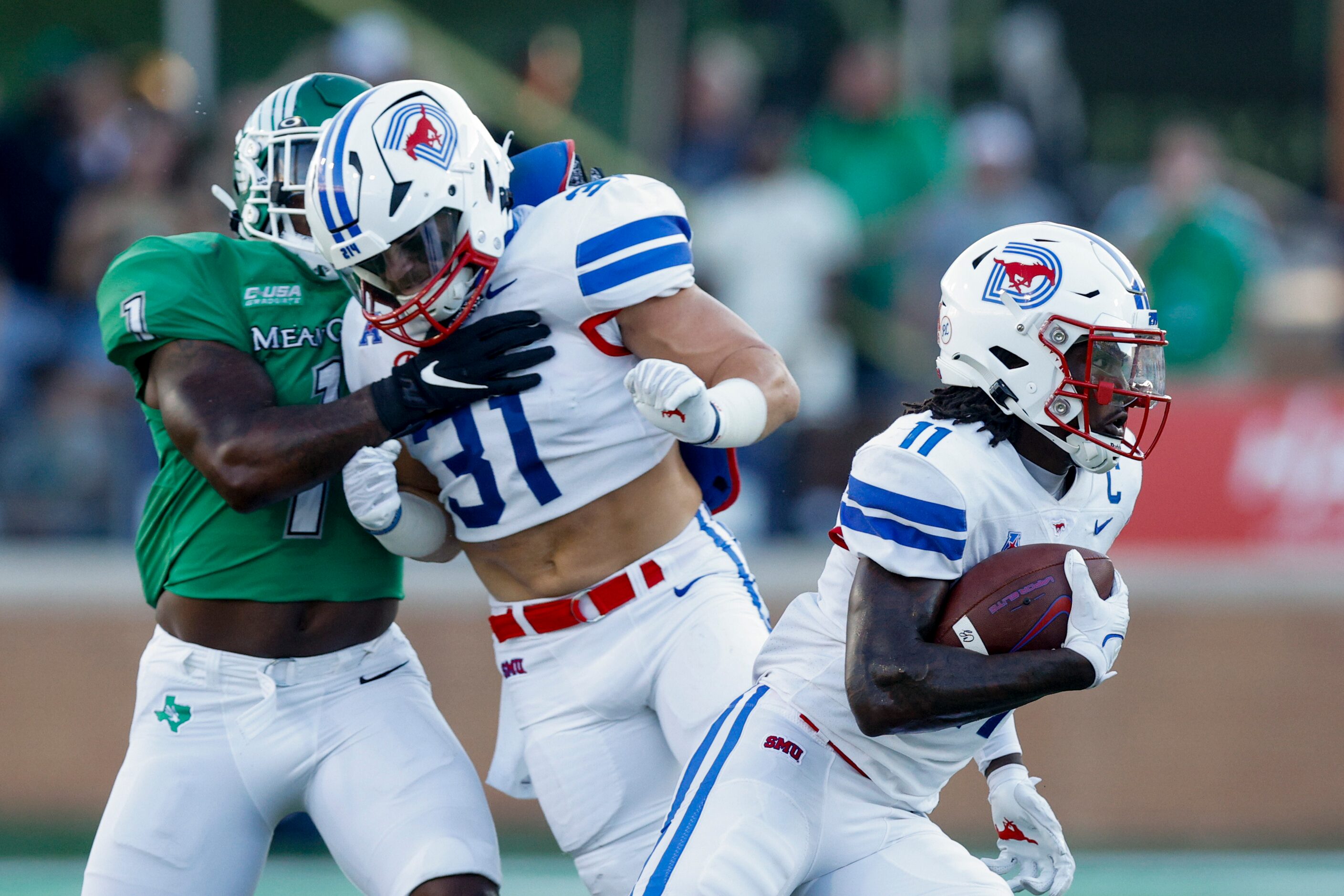 SMU running back Tyler Lavine (31) blocks UNT linebacker KD Davis (1) as wide receiver...