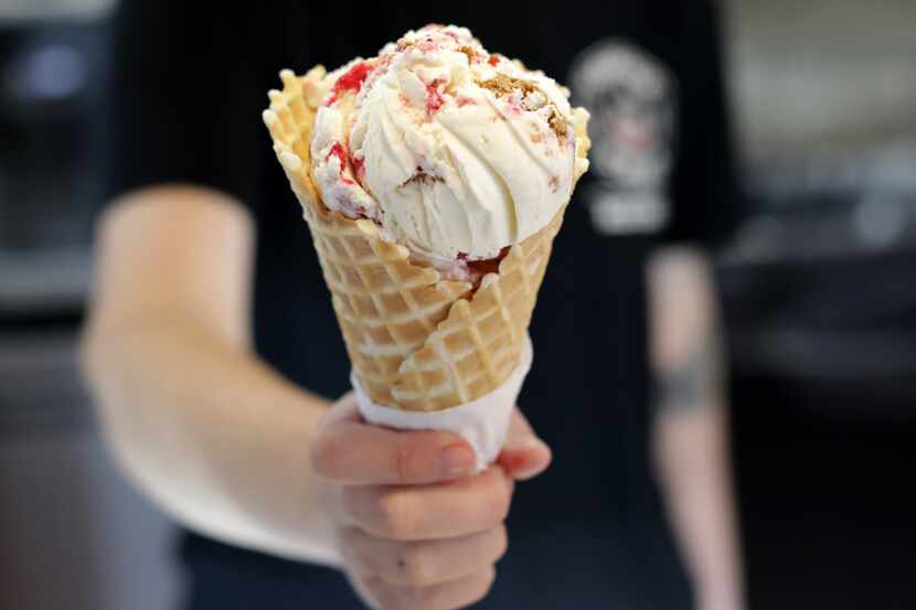 Josie Mcgillem holds a cranberry orange gingerbread cheesecake ice cream cone at Tongue in...