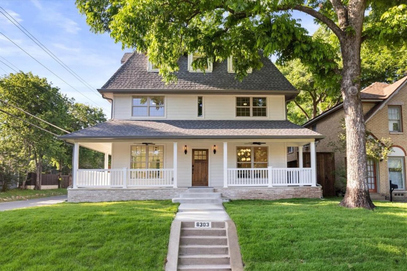 Exterior of a prairie style three-story home with a wraparound porch.