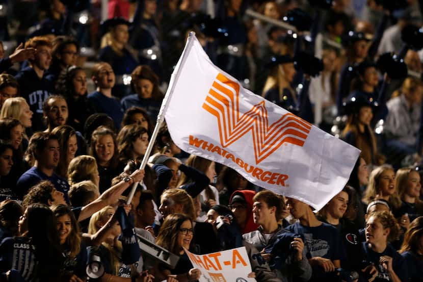 Frisco Lone Star senior Dustin Light waves a Whataburger flag as fans cheer in a game...