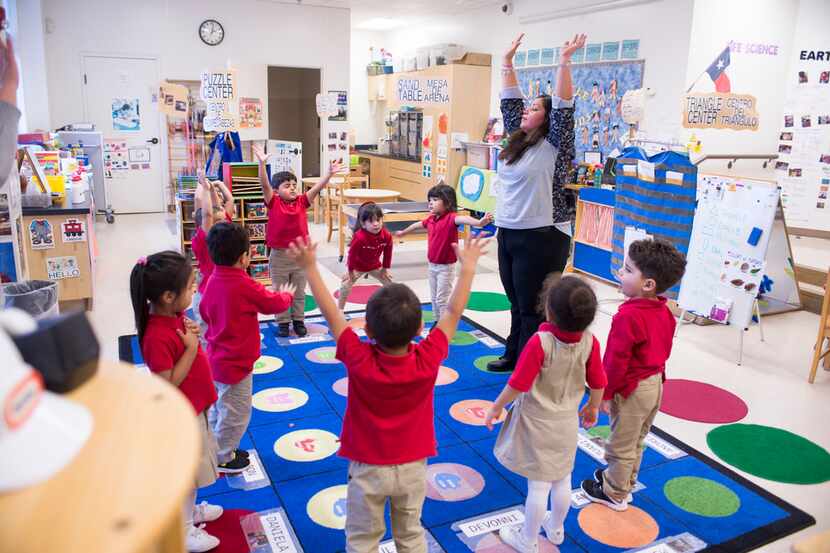 A pre-K teacher leads 3-year-old students in breathing exercises at the Momentous School.