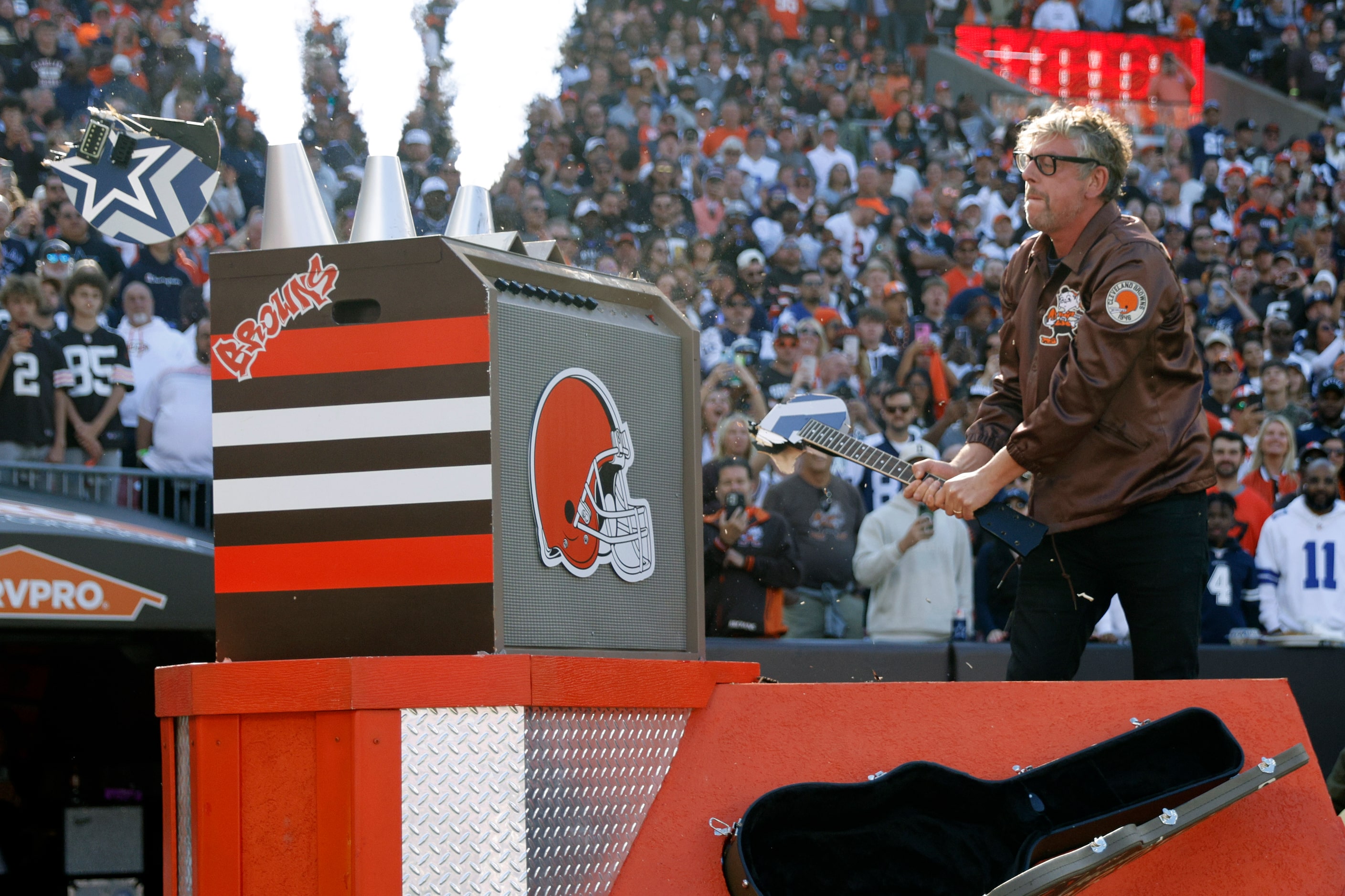 Patrick Carney of The Black Keys smashes a Dallas Cowboys themed guitar before a game...