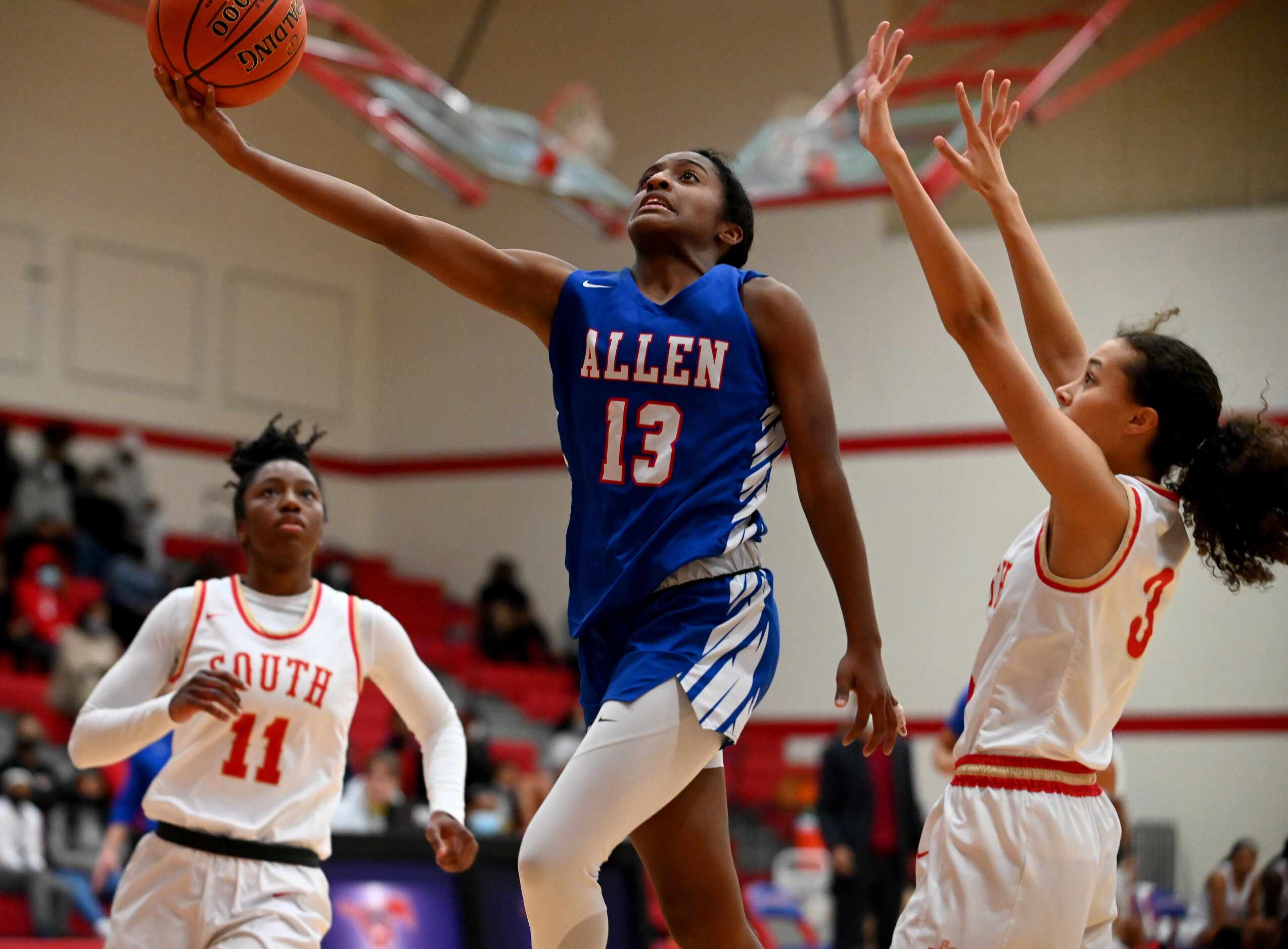 Allen’s Zoe Jackson (13) drives the basket between South Grand Prairie’s Jahcelyn Harris...