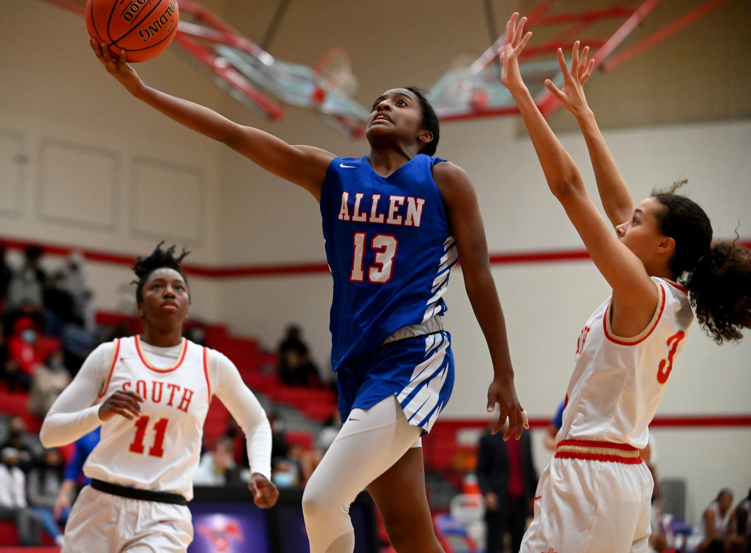 Allen’s Zoe Jackson (13) drives the basket between South Grand Prairie’s Jahcelyn Harris...