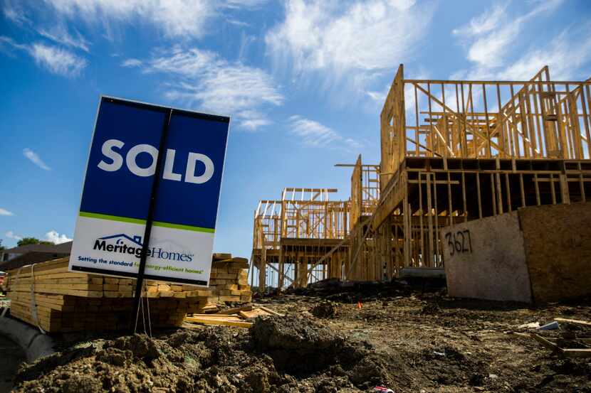 A new home is under construction next to a sold sign inside the Meritage Homes Villas at Los...