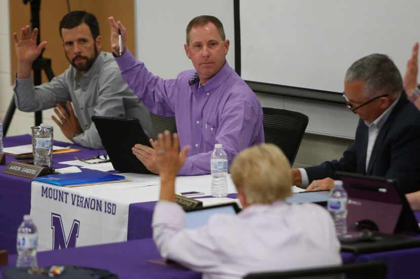 Mount Vernon school board president Aaron Sanders, center, calls for a vote of the board as...