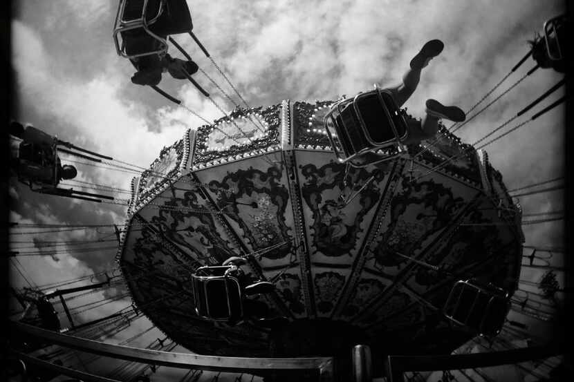 Riders go almost horizontal as they ride the Wave Swinger on the Midway at the State Fair of...