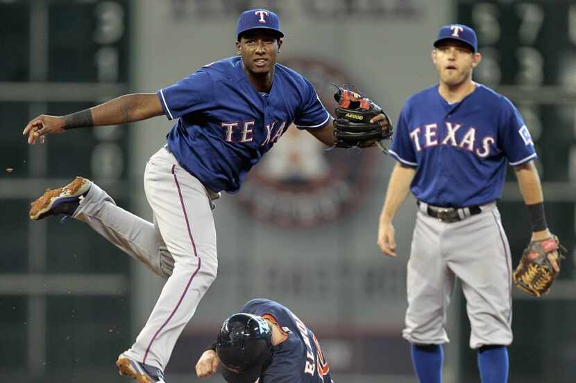 Jurickson Profar #13 of the Texas Rangers avoids the slide of Jake Elmore #10 of the Houston...