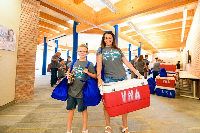 mother and son with a VNA Texas cooler headed out to deliver Meals on Wheels