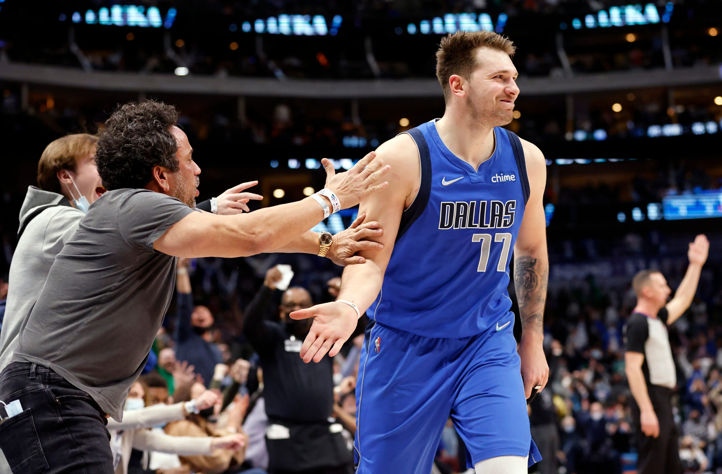 Court-side fans congratulate Dallas Mavericks guard Luka Doncic (77) after he made an...